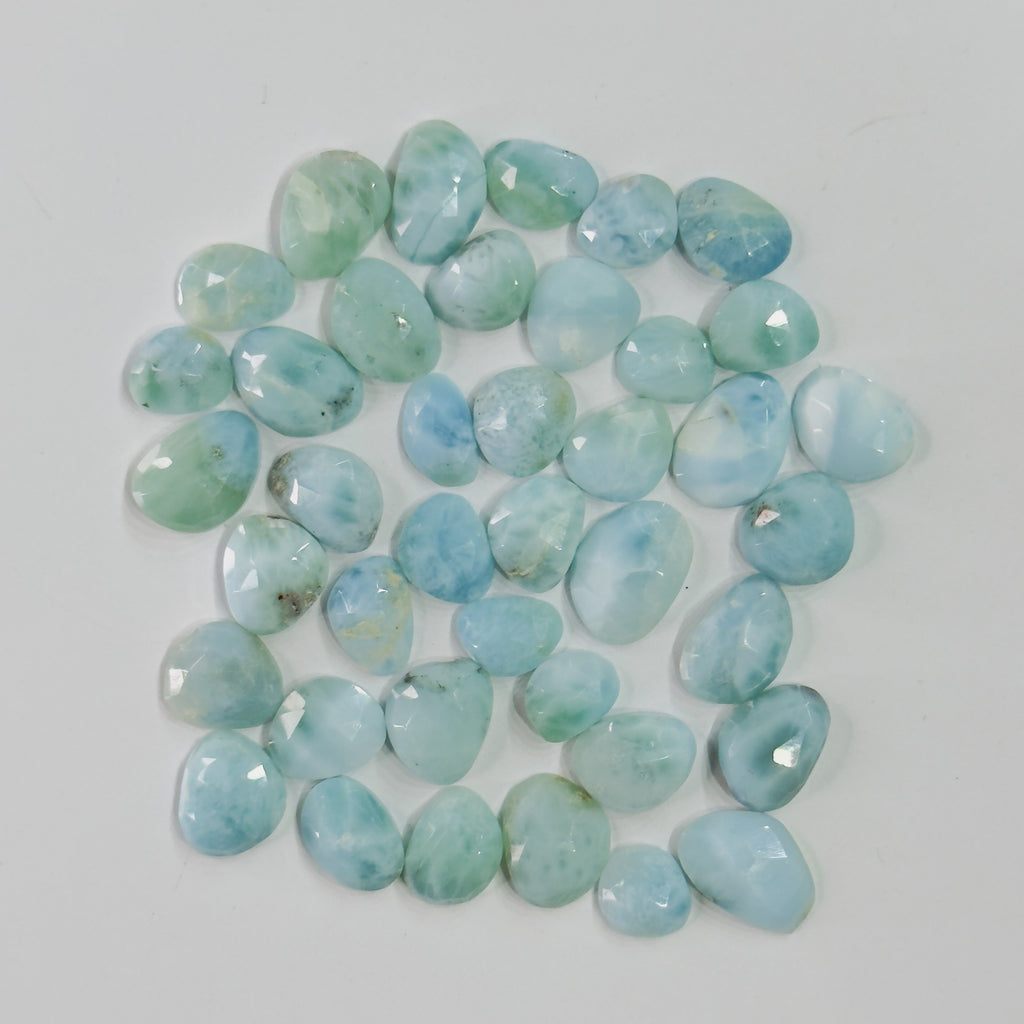 Collection of light blue and green stones on a white background