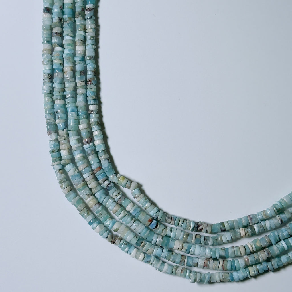 String of turquoise beads on a light gray background
