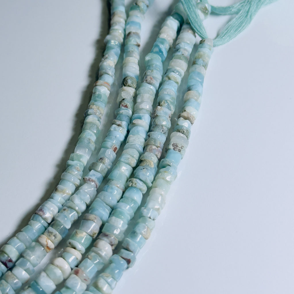 String of light blue beads on a white background