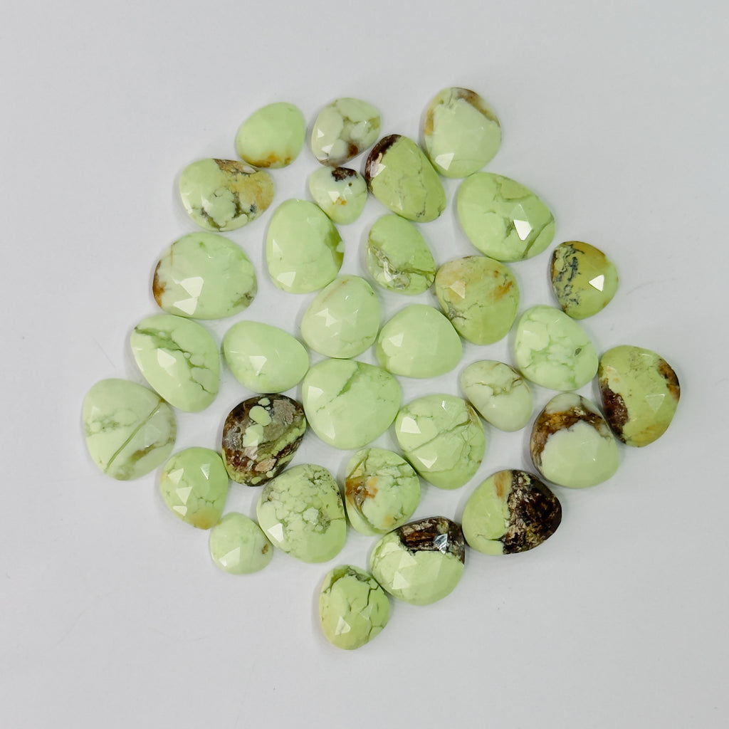 Collection of green turquoise stones on a light gray background