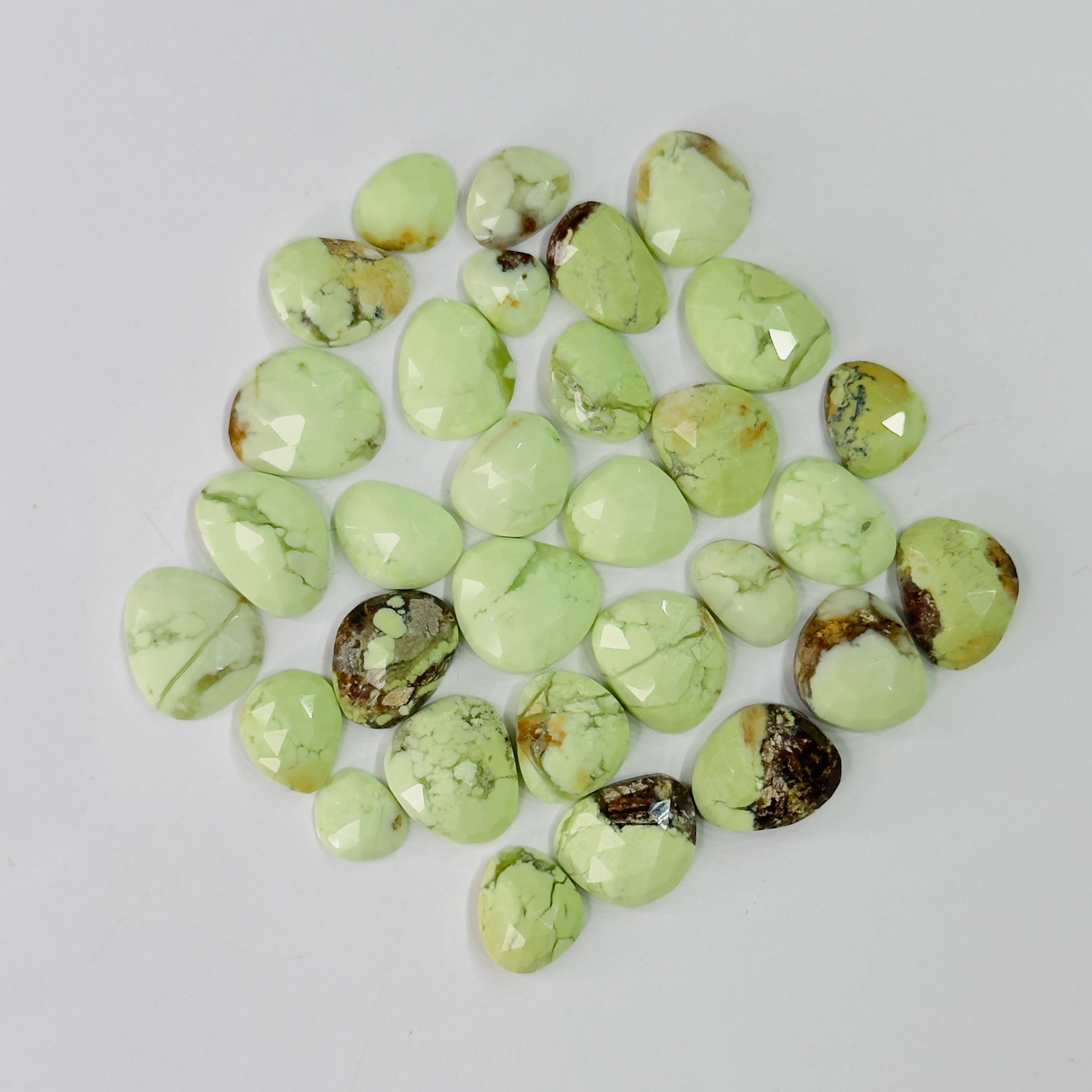 Collection of green turquoise stones on a light gray background