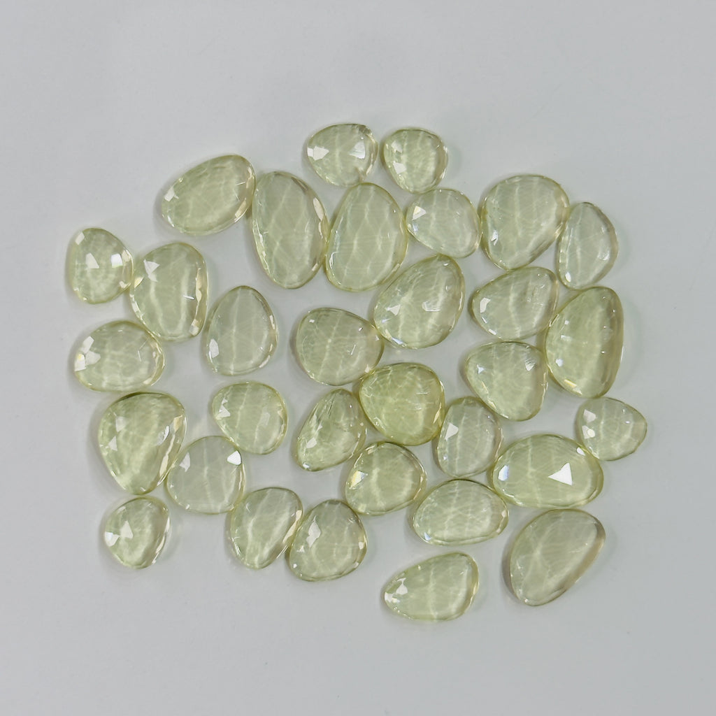 Collection of light green faceted stones on a gray background