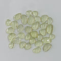 Collection of light green faceted stones on a gray background