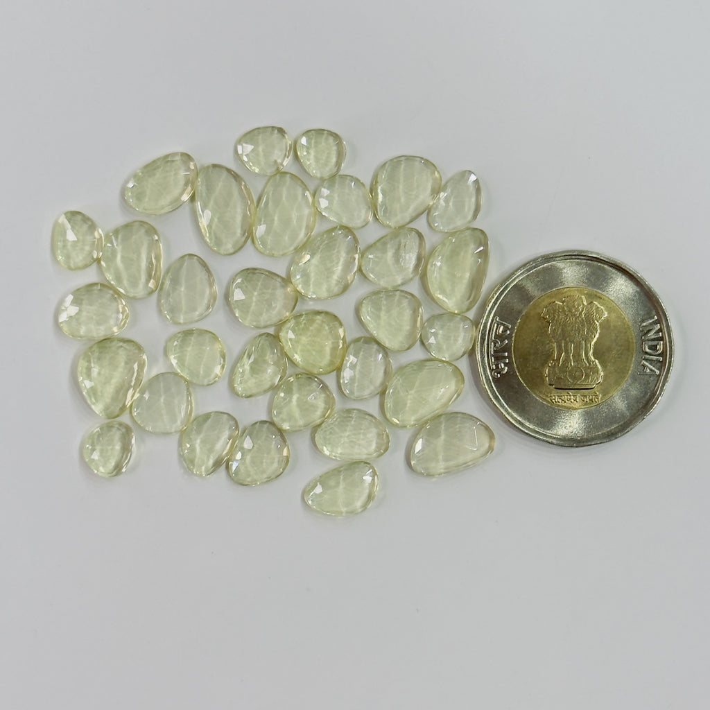 Transparent stones next to a coin on a gray background