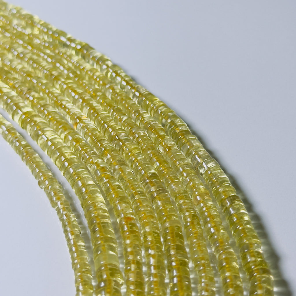 Close-up of yellow gemstone beads on a light gray background