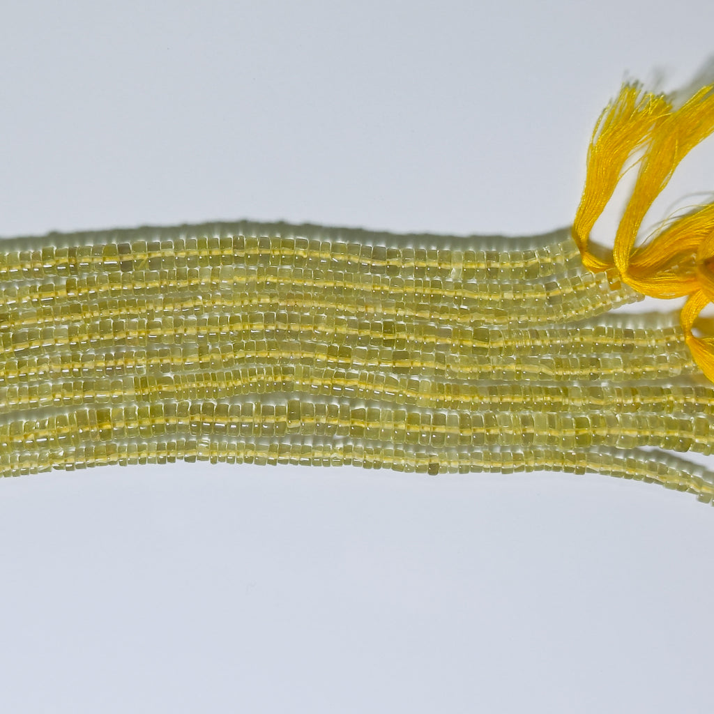 Close-up of yellow beaded string on a light gray background