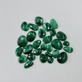 Collection of green gemstones on a light gray background