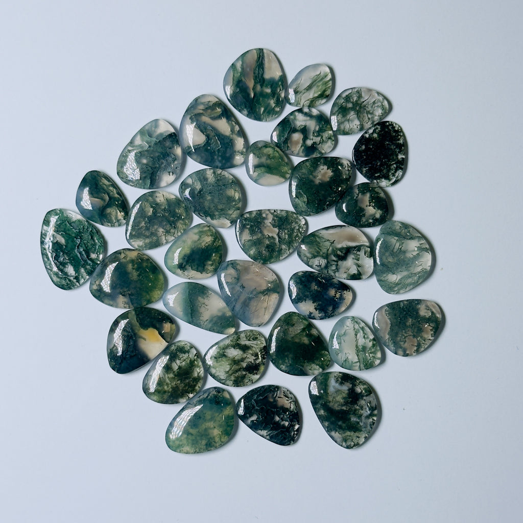 Collection of green and black marbled stones on a light gray background
