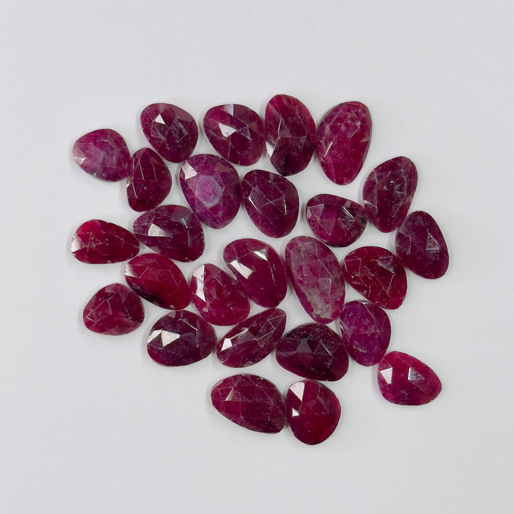 Collection of red gemstones on a light gray background