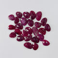 Collection of red gemstones on a light gray background
