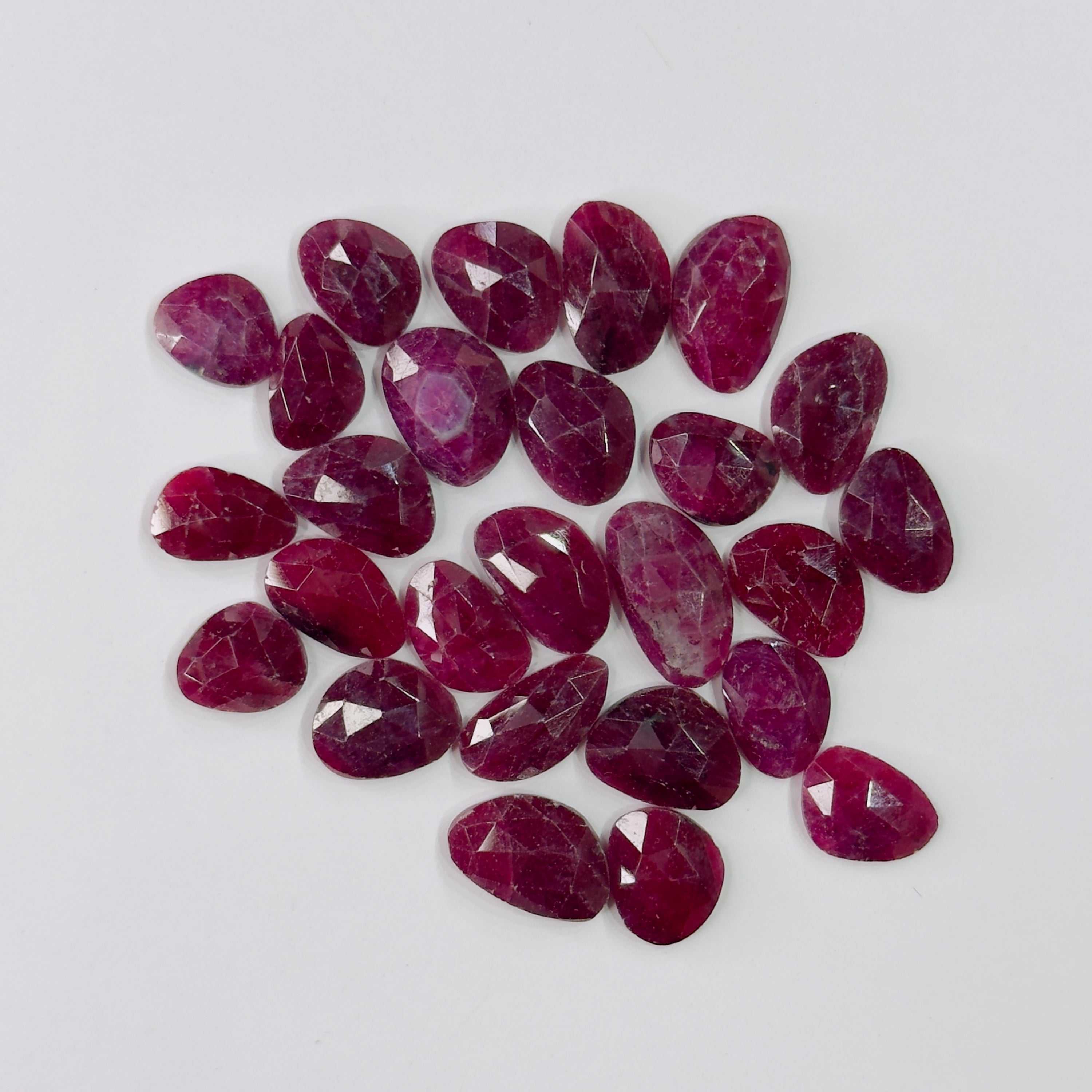 Collection of red gemstones on a light gray background