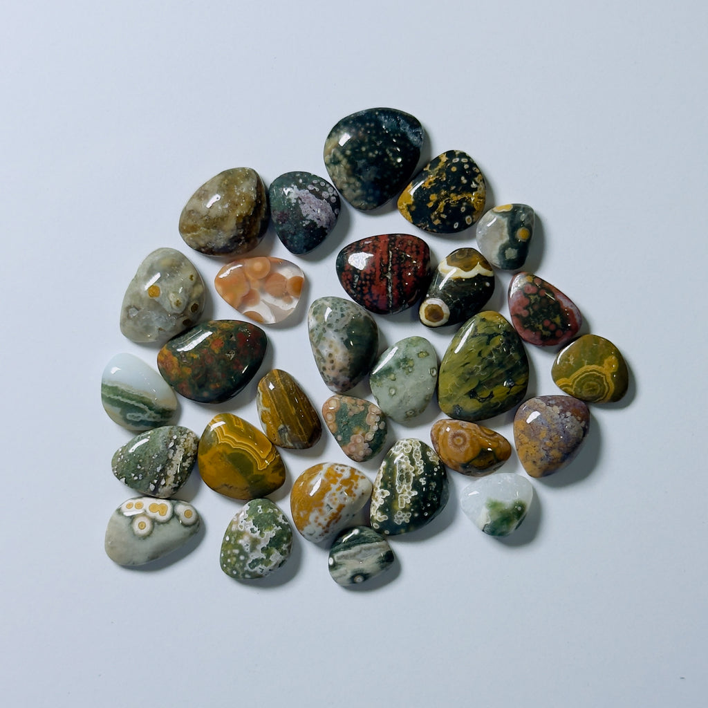 Collection of multicolored marbled stones on a white background