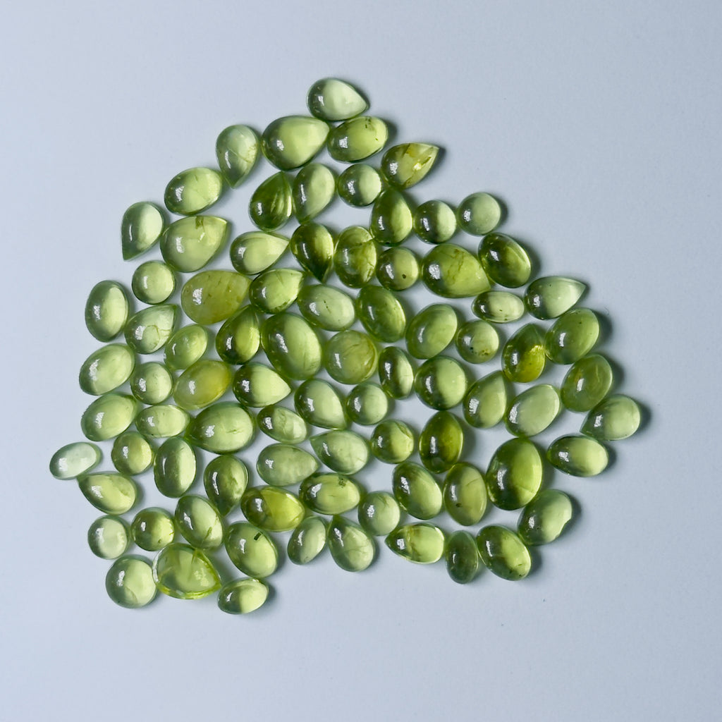 Green teardrop-shaped gemstones on a white background