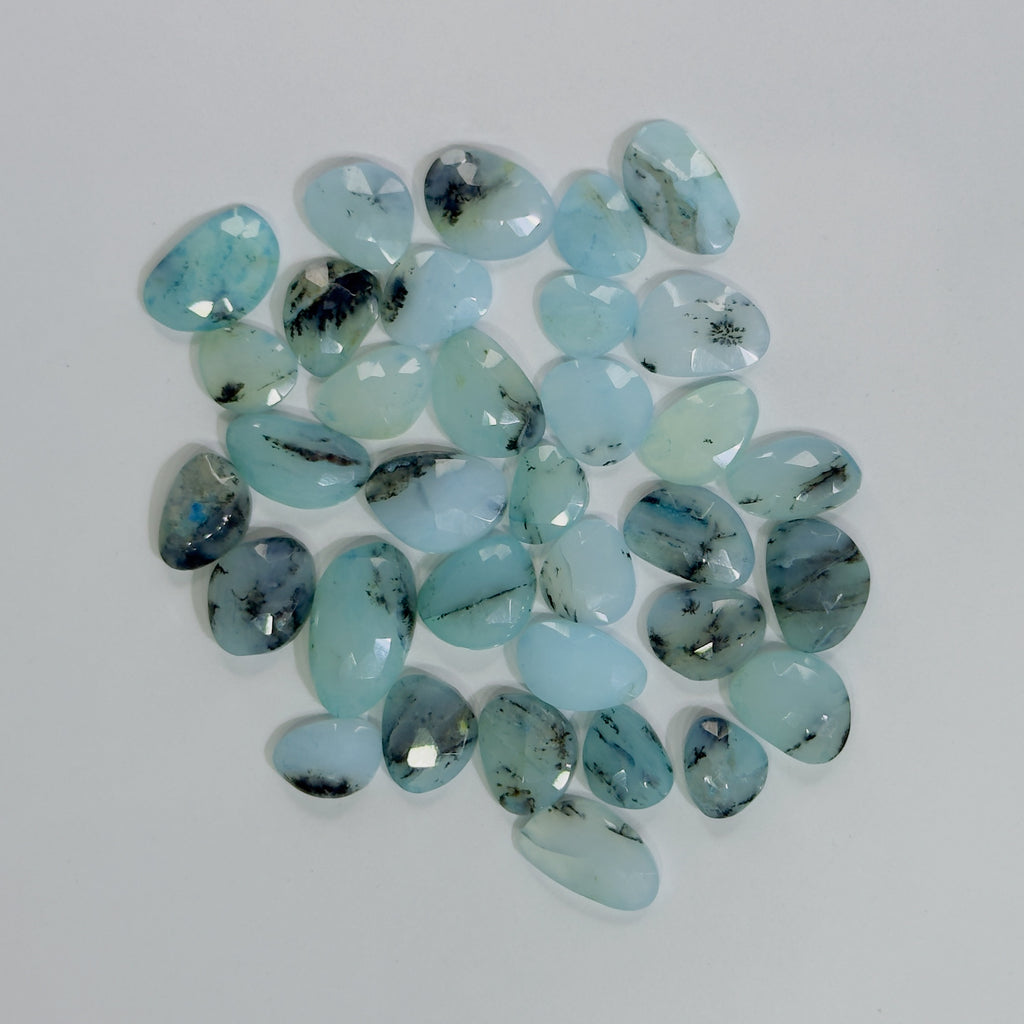 Collection of light blue gemstones on a white background