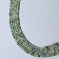 Necklace with green and black beaded strands on a white background