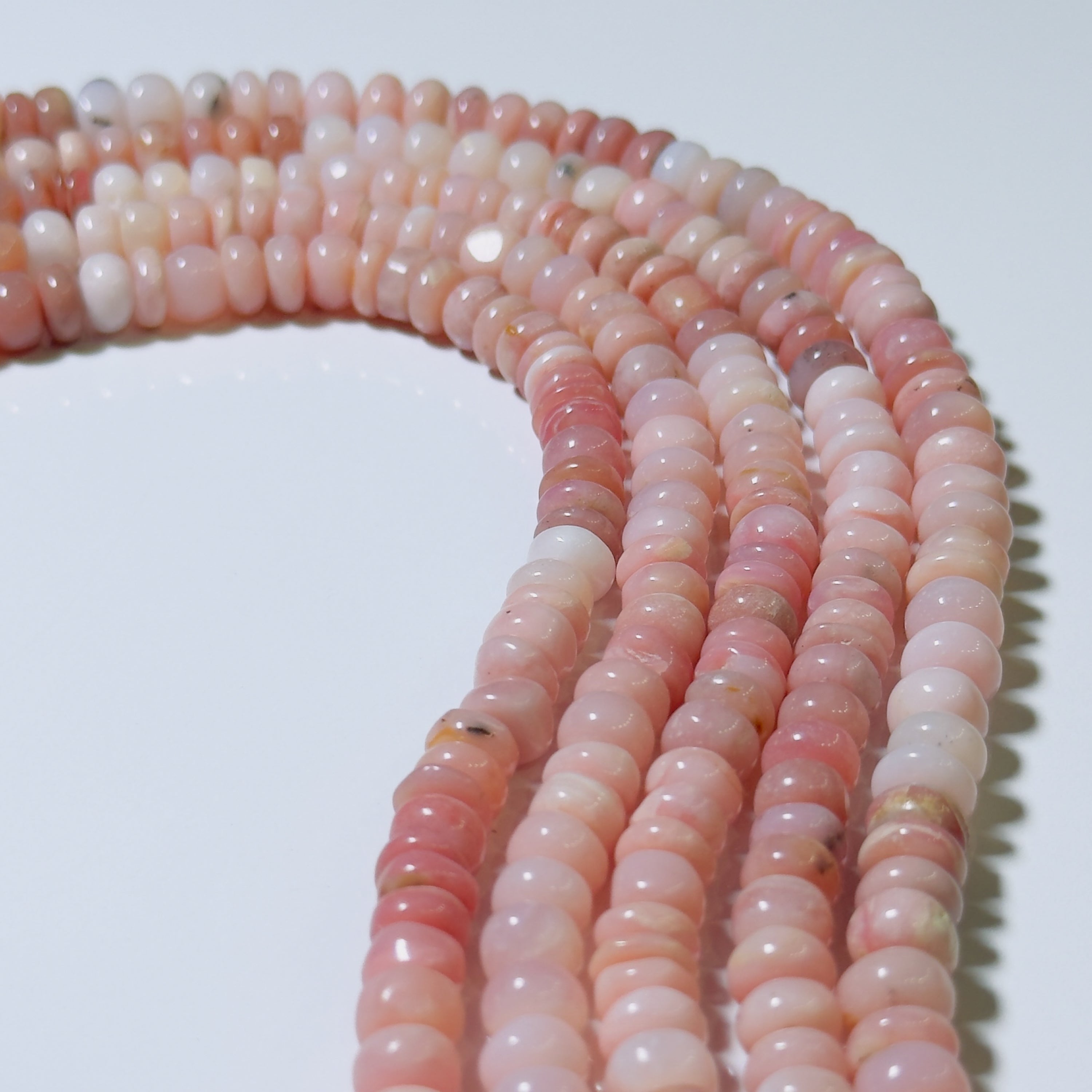 Necklace of pink and white beads on a white background