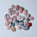 Collection of pink and black marbled stones on a white background