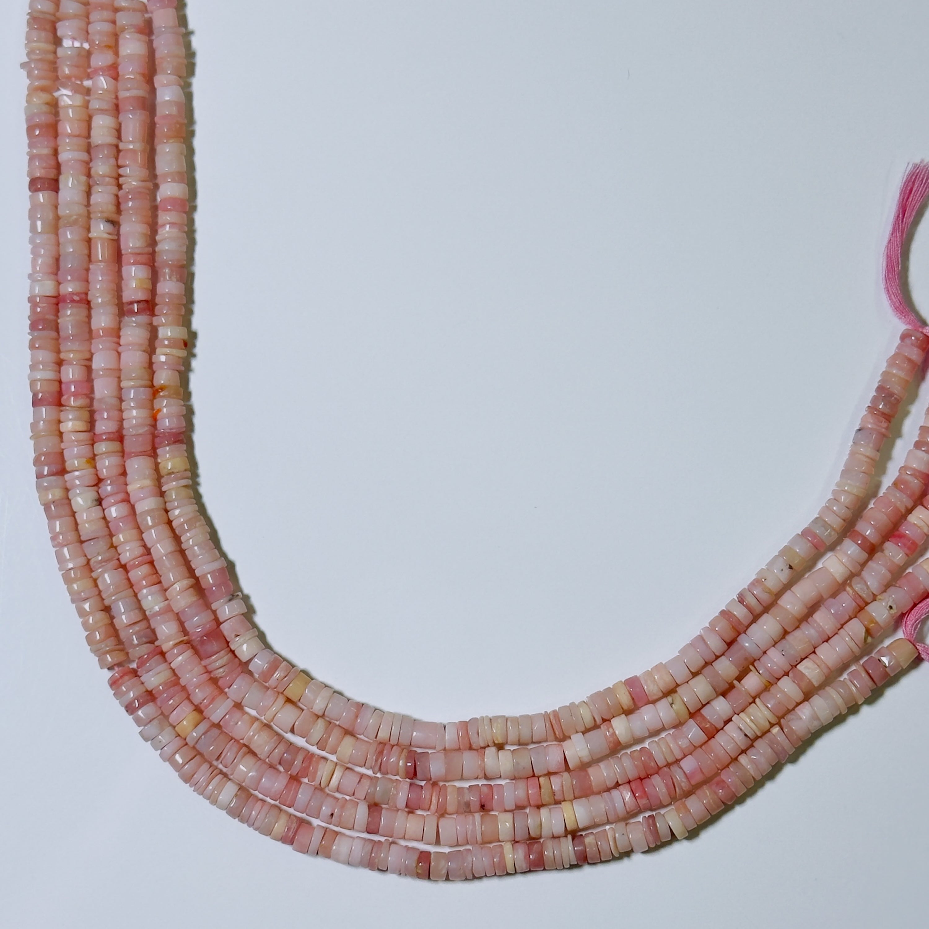 Necklace with pink and red beads on a light gray background