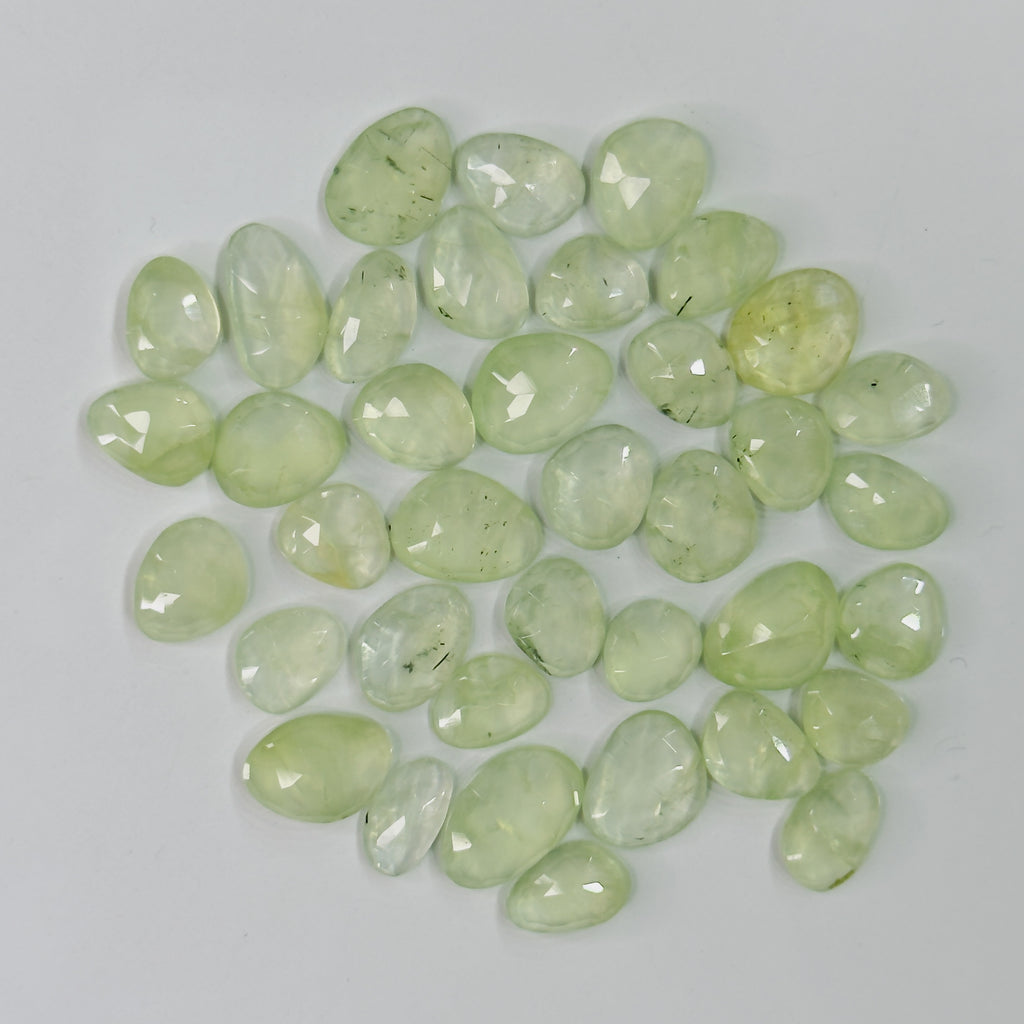 Collection of light green teardrop-shaped stones on a white background