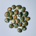 Collection of green and orange marbled stones on a White