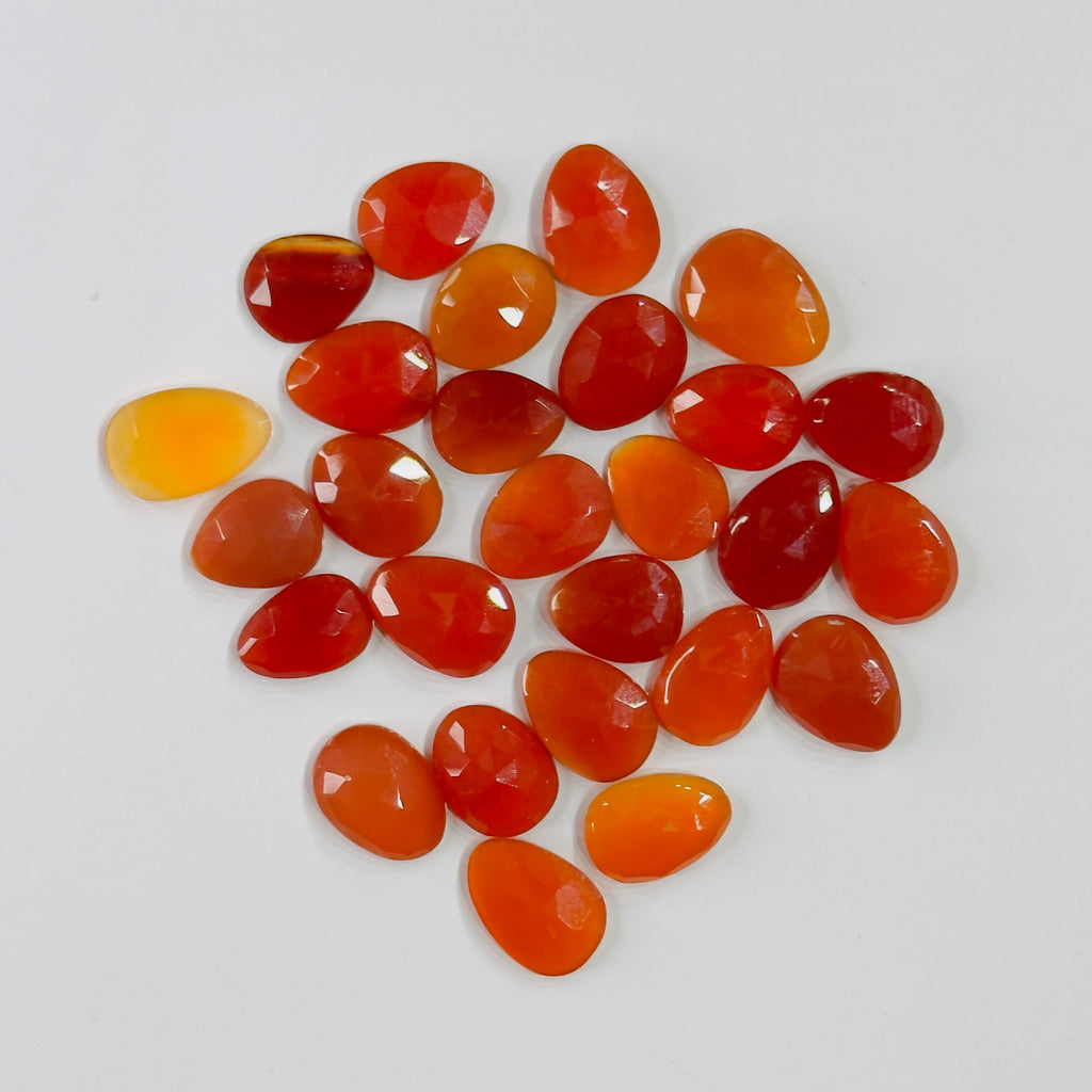 Collection of orange teardrop-shaped stones on a white background
