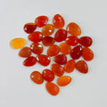 Collection of orange teardrop-shaped stones on a white background