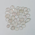 Collection of faceted gemstones on a light gray background