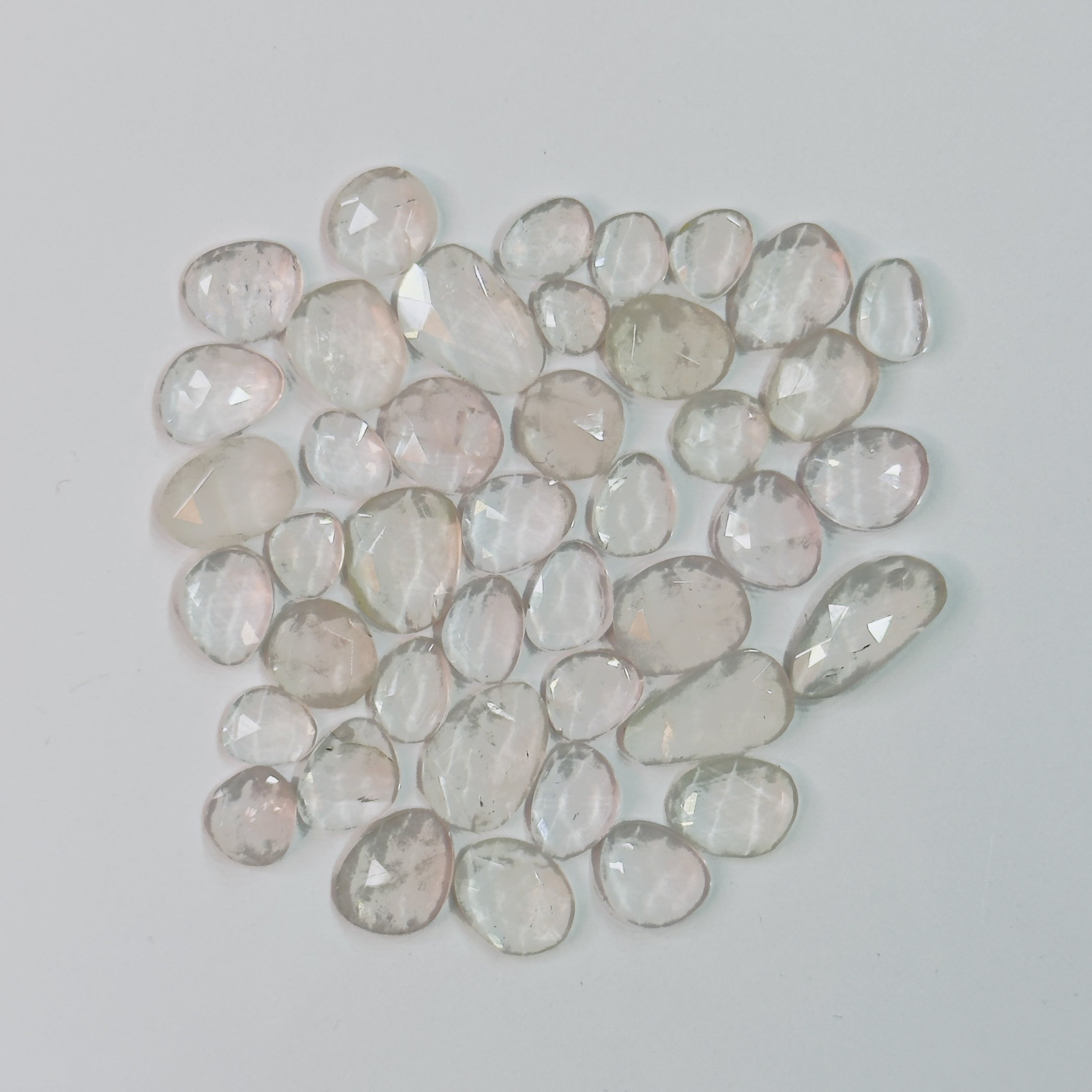 Collection of faceted gemstones on a light gray background