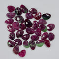 Collection of purple and green gemstones on a gray background