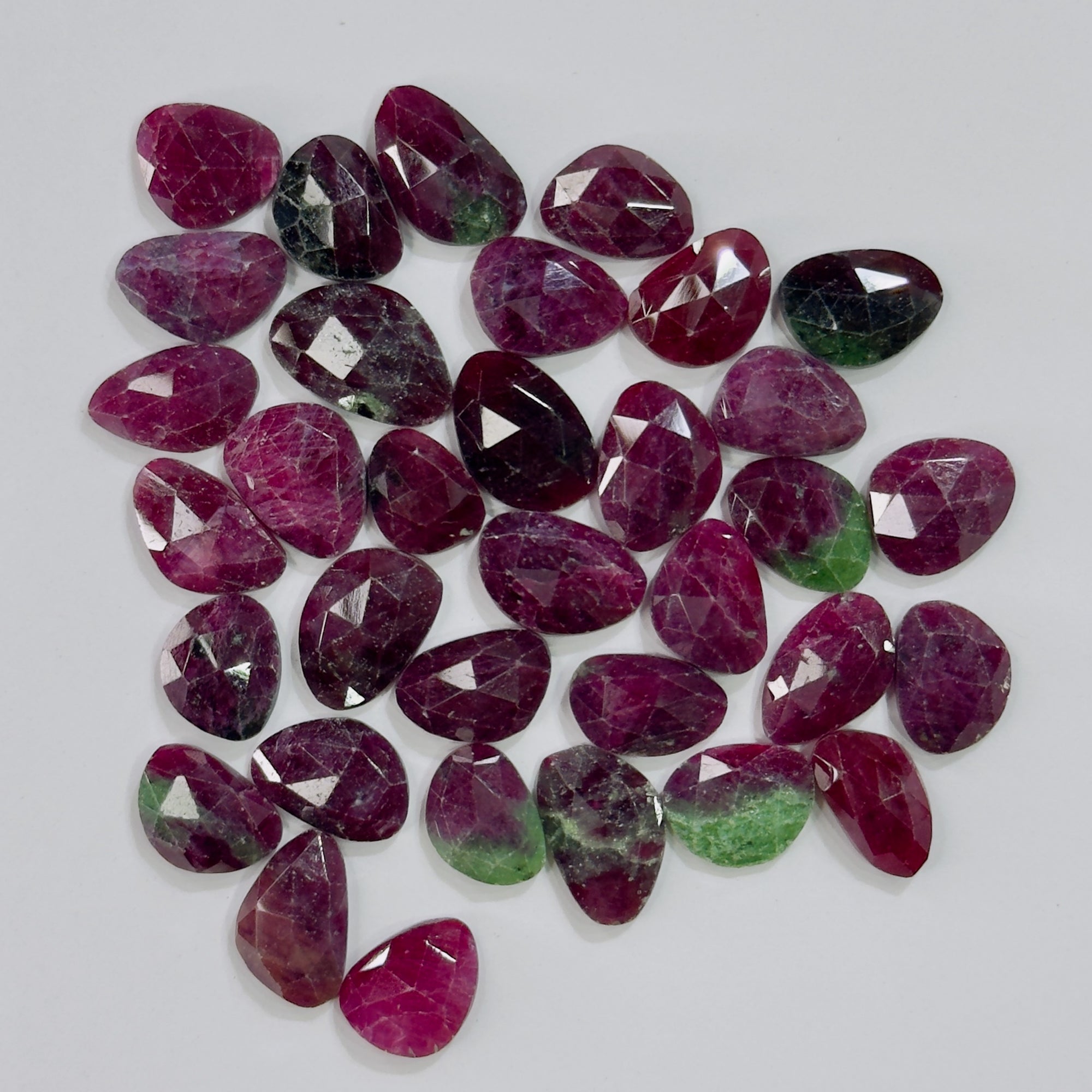 Collection of purple and green gemstones on a gray background