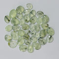 Collection of greenish crystals on a light gray background