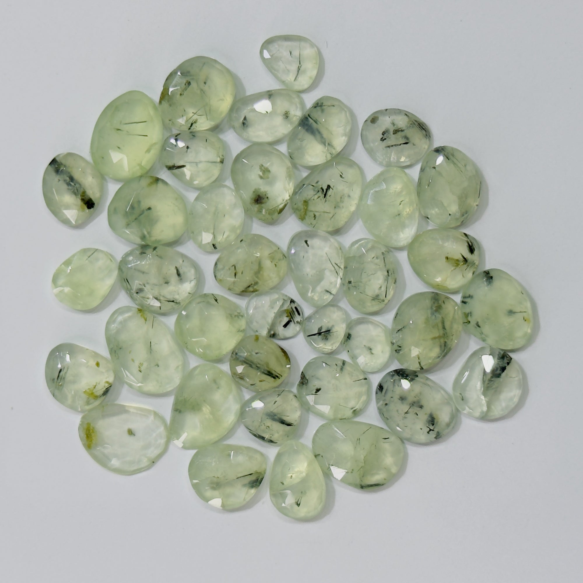 Collection of greenish crystals on a light gray background