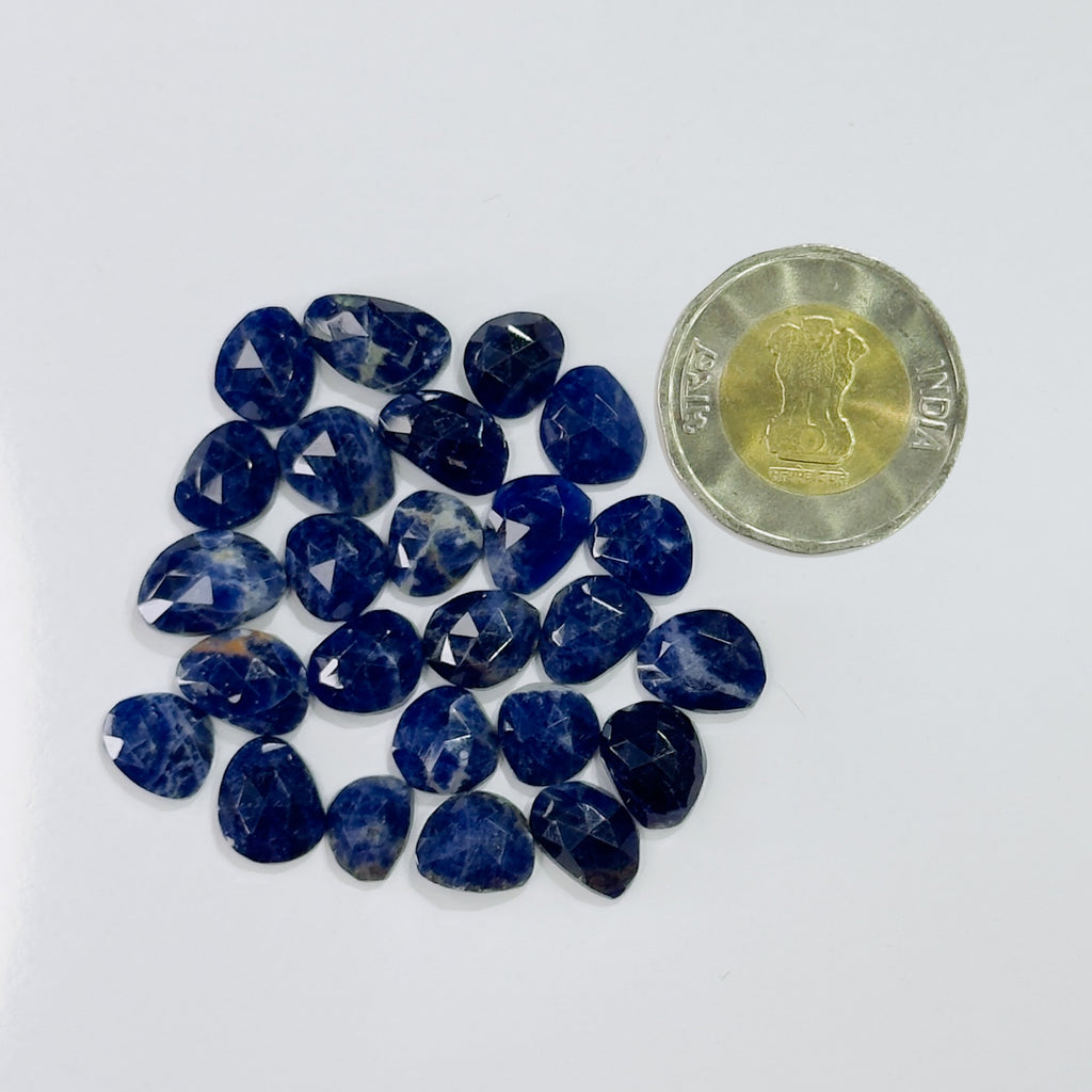 Blue stones arranged on a white surface with a coin for scale.