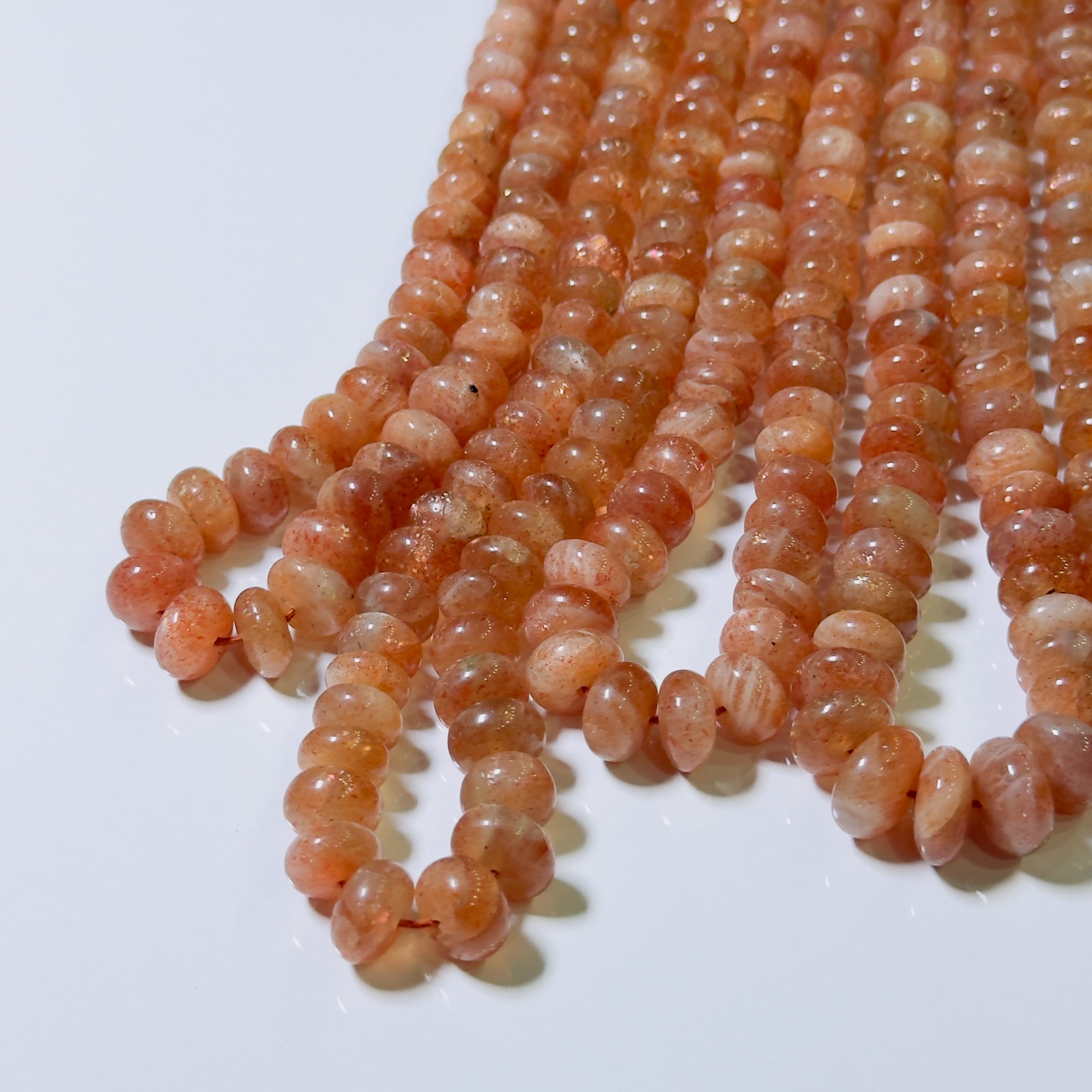 Strand of orange beads on a white background