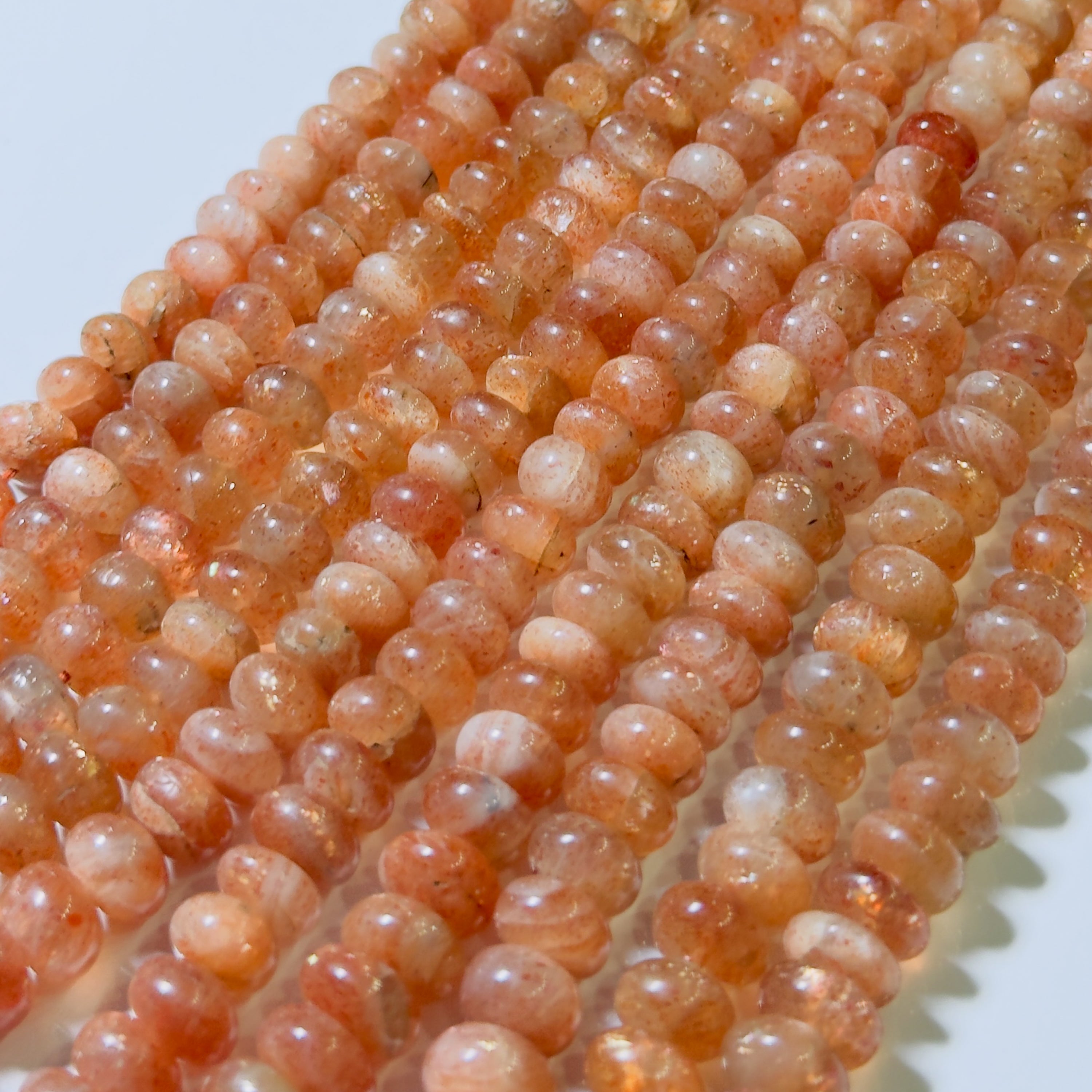 Strand of peach-colored beads on a white background
