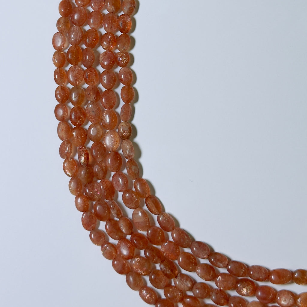Strand of orange beads on a white background