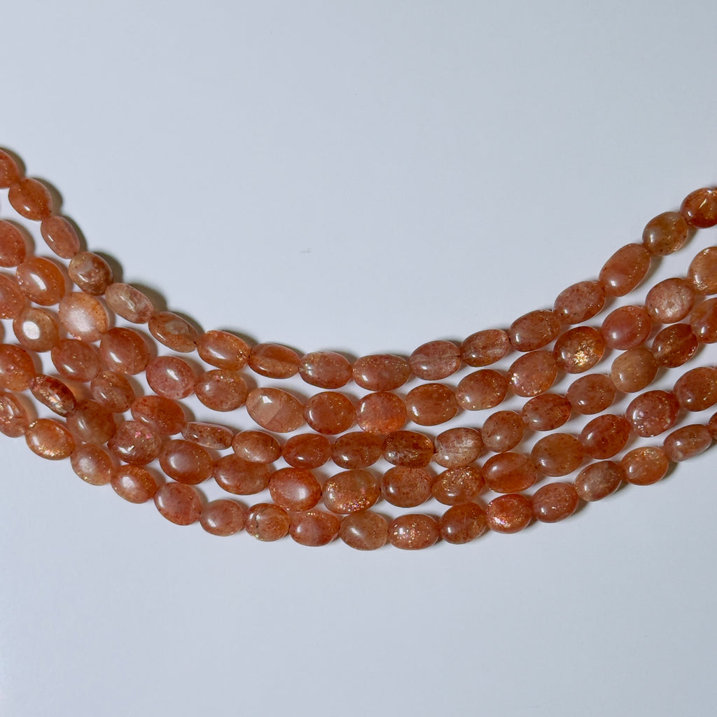 Necklace with orange beads on a light gray background