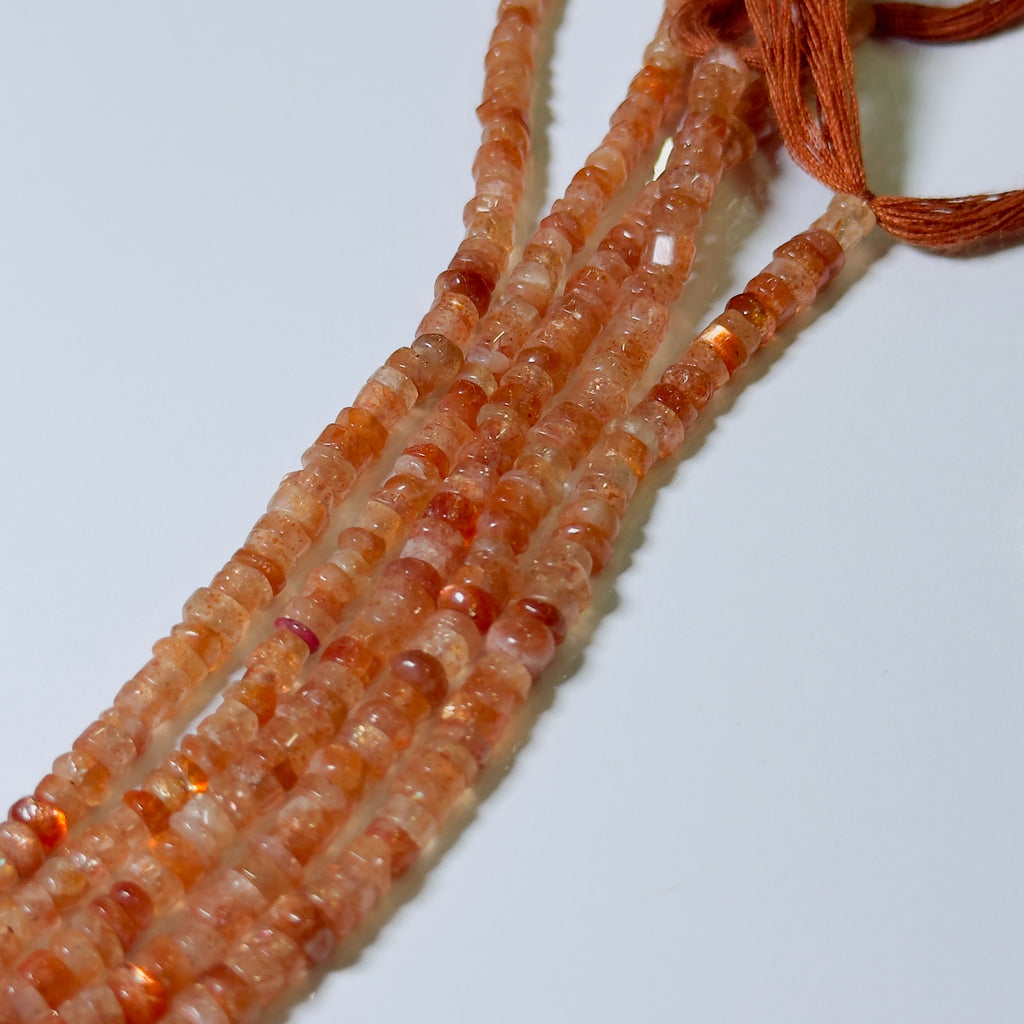 Strand of orange beads on a white background
