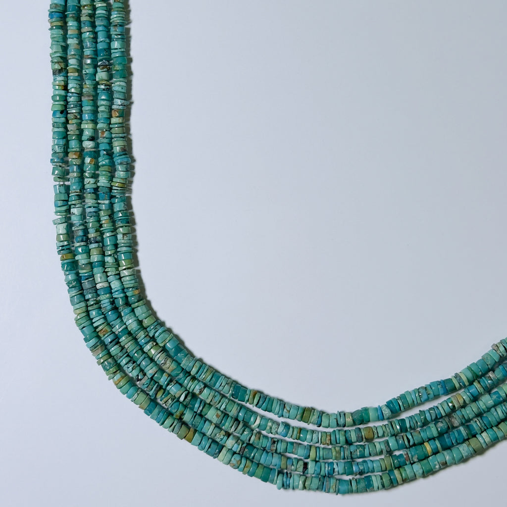 Turquoise bead necklace on a light gray background