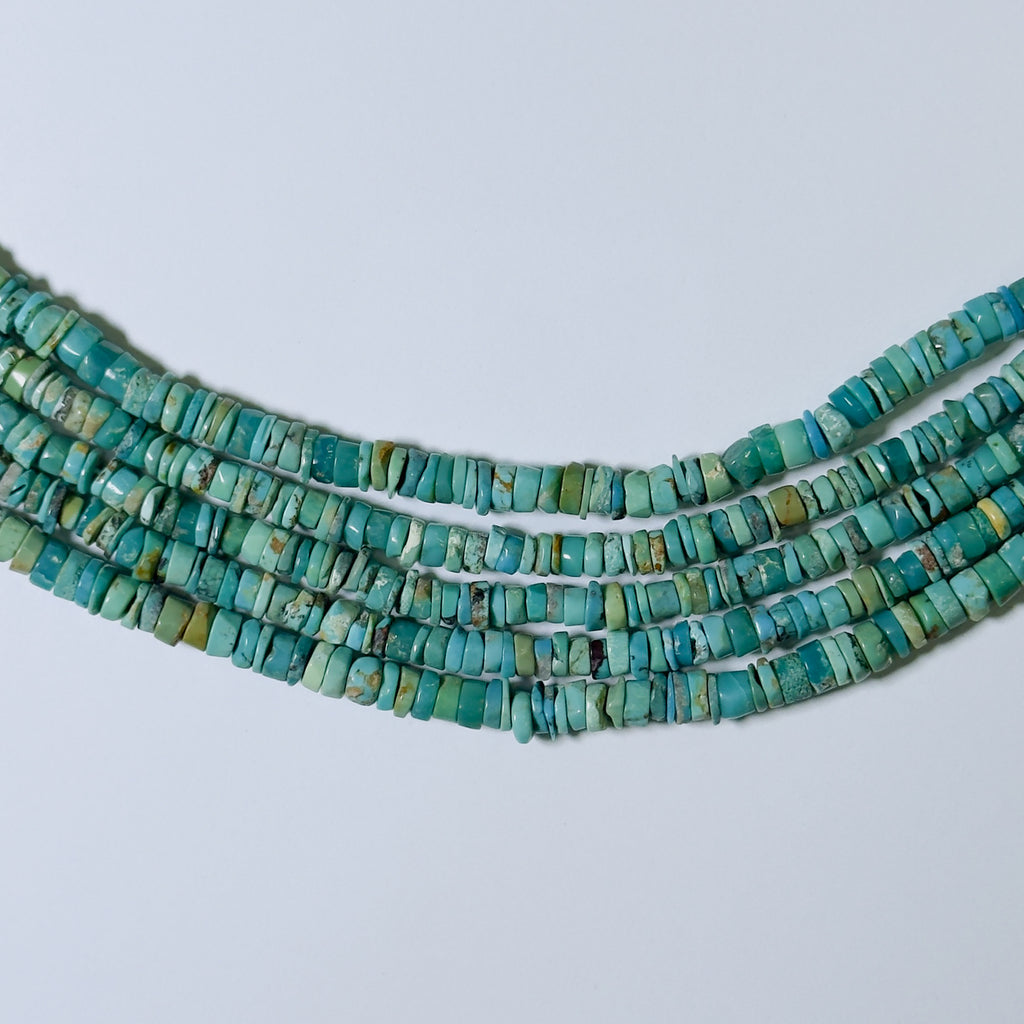 Turquoise bead necklace on a light gray background