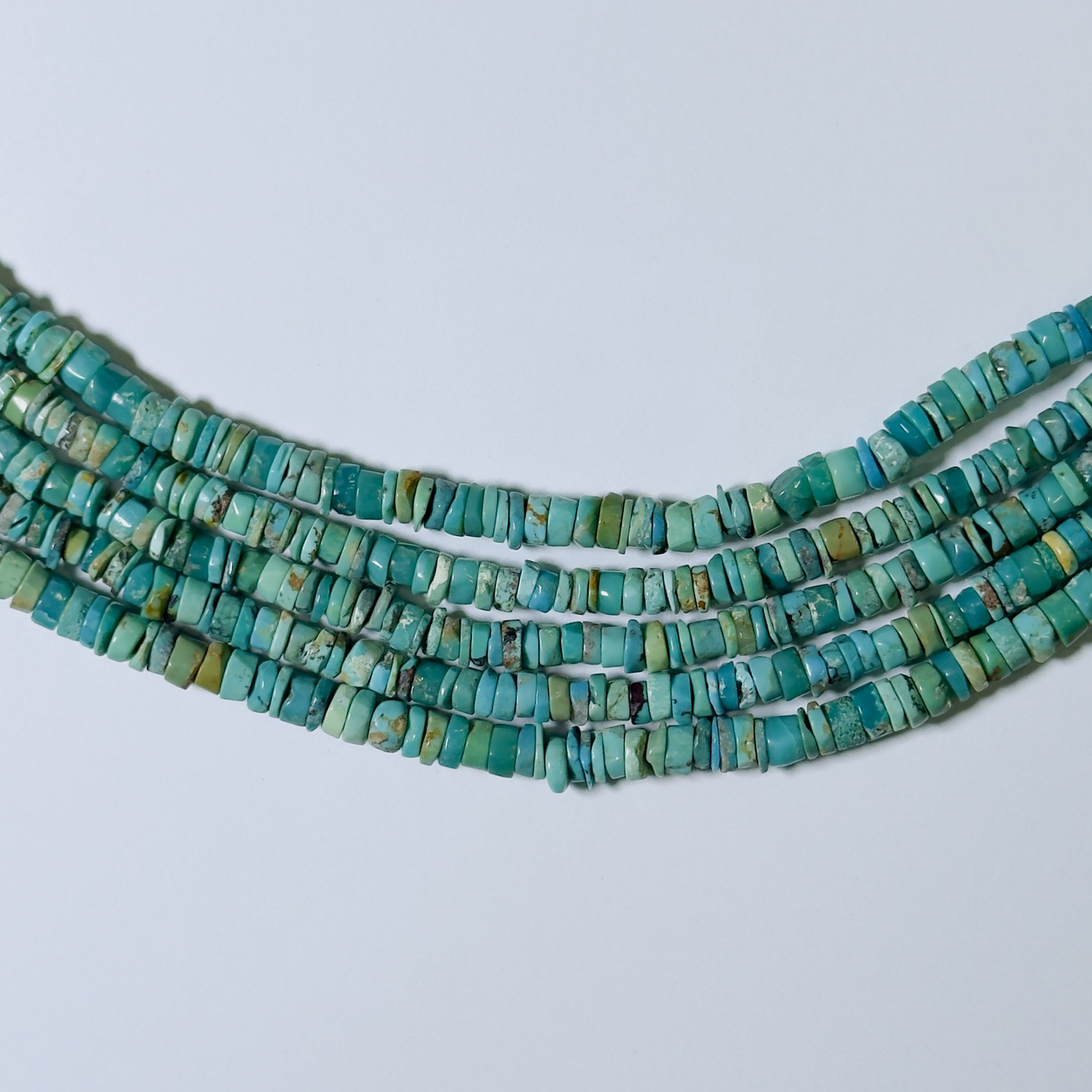 Turquoise bead necklace on a light gray background