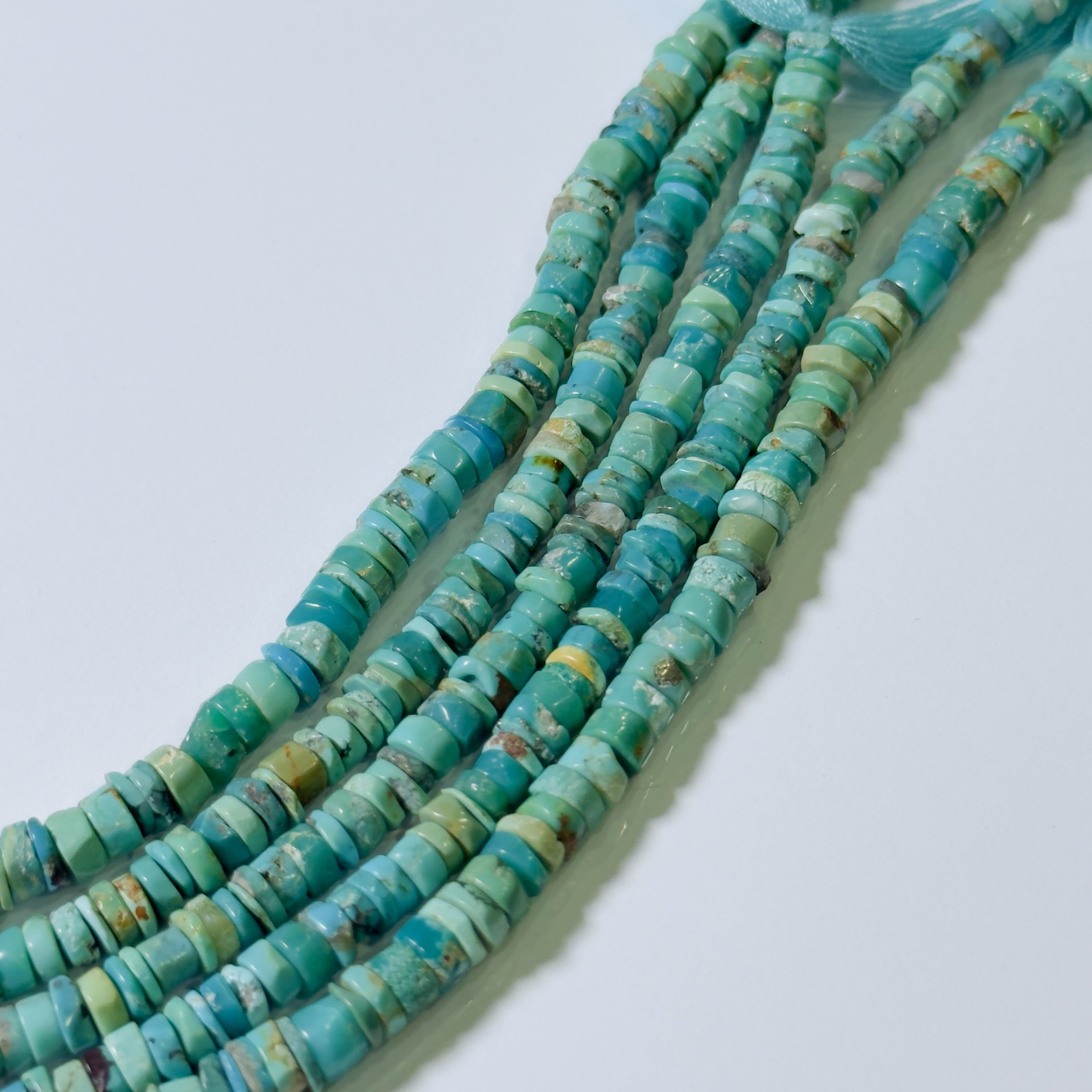 Turquoise bead necklace on a light blue background