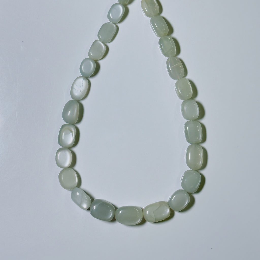 A beaded necklace made of smooth, rounded, light greenish-white stone beads arranged in a teardrop shape on a plain light gray background.